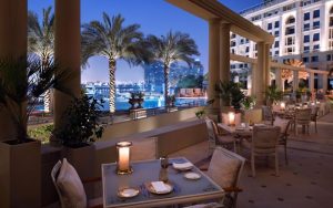 Luxury hotel outdoor dining with palm trees and city view
