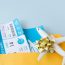 Flight tickets in an envelope with a gift-wrapped airplane model