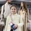 Girl with passport at airport, parents in background