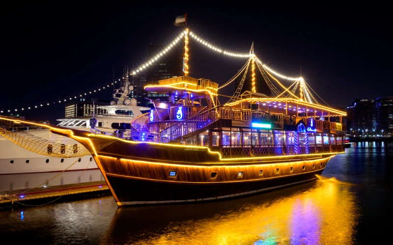 Illuminated dhow cruise boat at night in Dubai