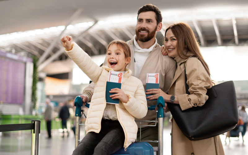 Excited family at airport with passports and boarding passes