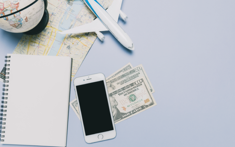 Travel planning essentials with map, money, phone, and airplane model
